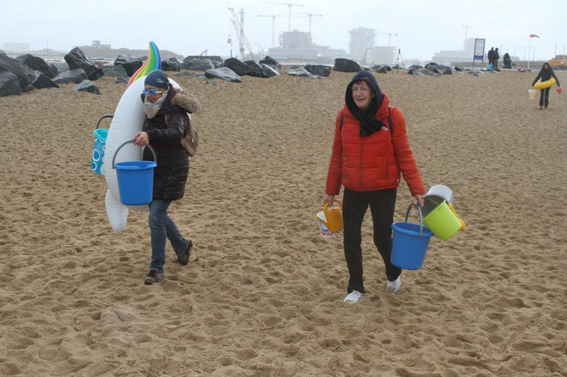 Vzw Ithaka uit Oostende draagt water naar de zee bij ludieke actie