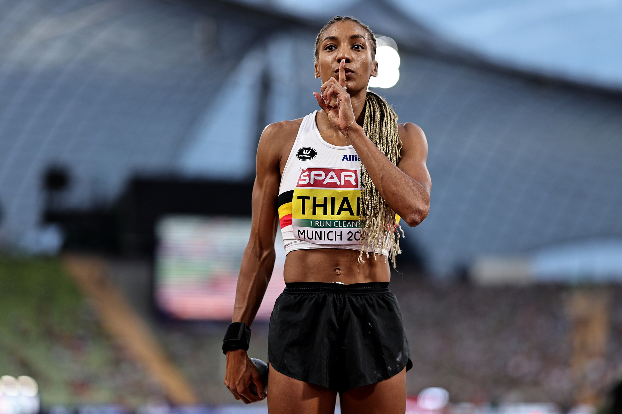 Nafi Thiam probeert het publiek in het Olympische stadion van München stil te krijgen voor haar worp in het kogelstoten.