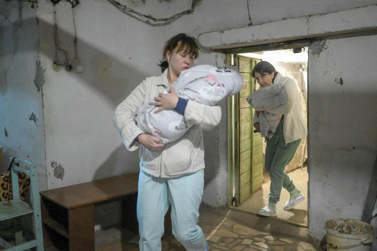 Des infirmières transportent des bébés au sous-sol de la maternité alors que les sirènes avertissent des raids aériens à Mykolaïv, le 14 mars 2022. Près de la moitié des 49 femmes ont dû accoucher au sous-sol depuis le 24 février., AFP